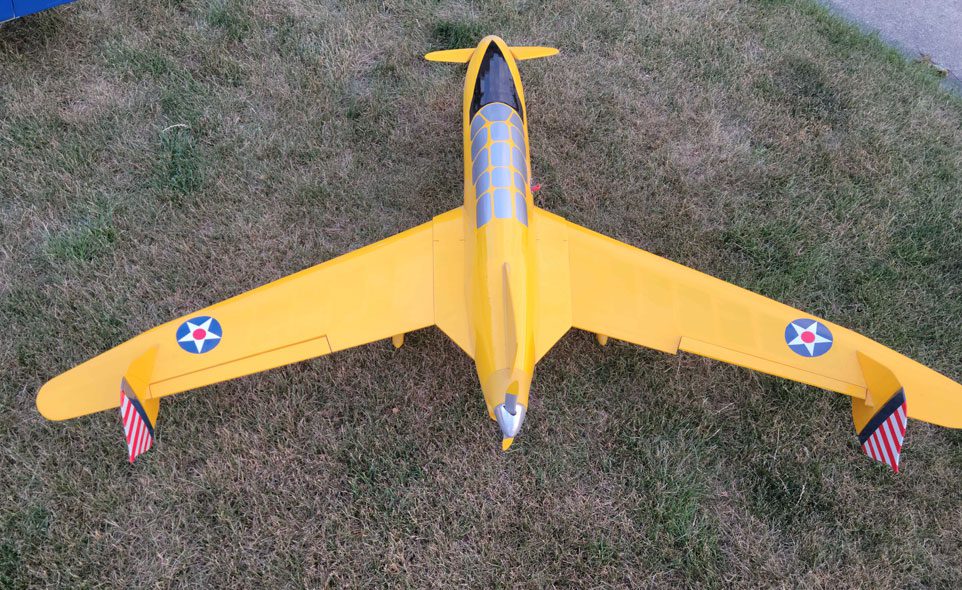 A yellow airplane is sitting on the grass.