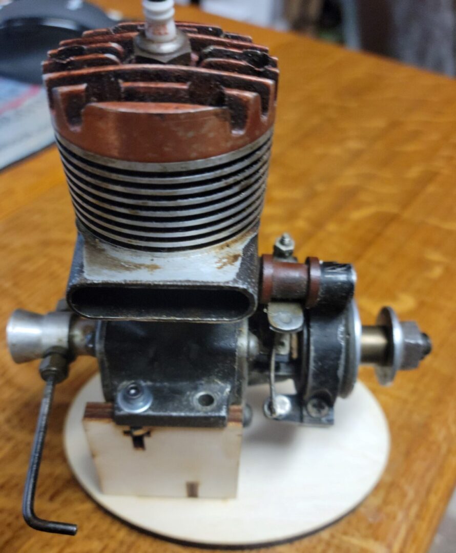 A small engine on top of a wooden base.