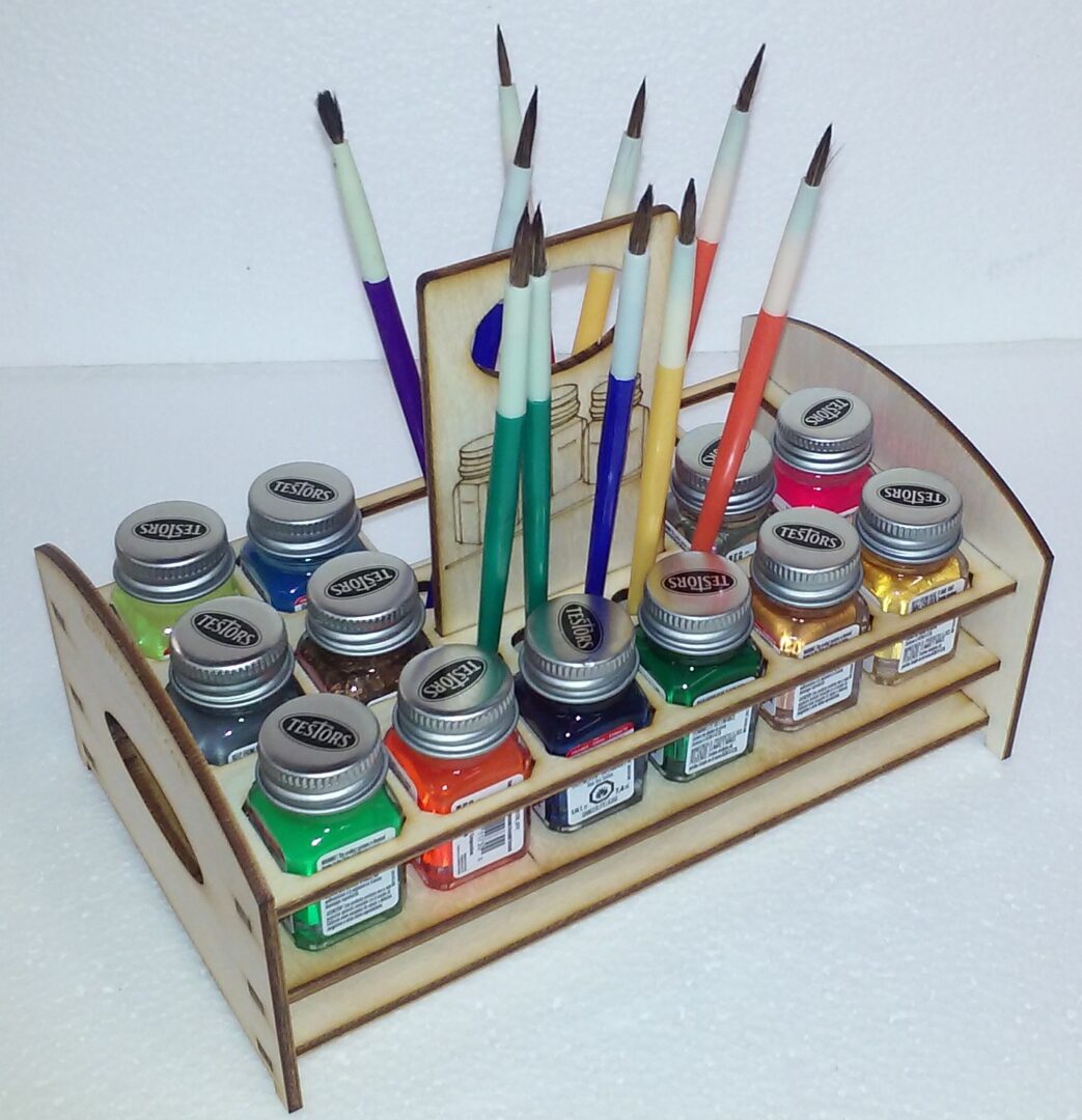A wooden paint holder with paint brushes and paint jars.