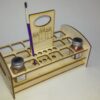 A wooden holder with a bottle of paint and a pencil.
