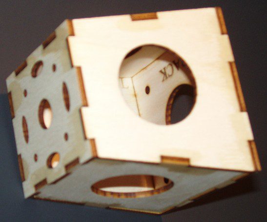 A wooden cube with a hole in the middle.