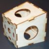 A wooden cube with holes in it.
