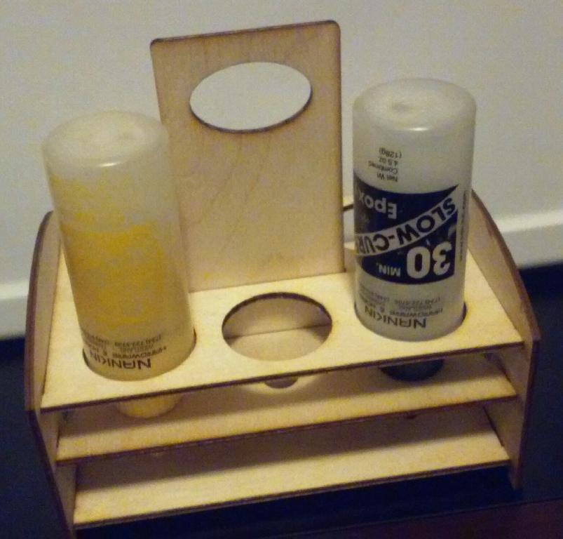 A wooden bottle holder with two bottles in it.