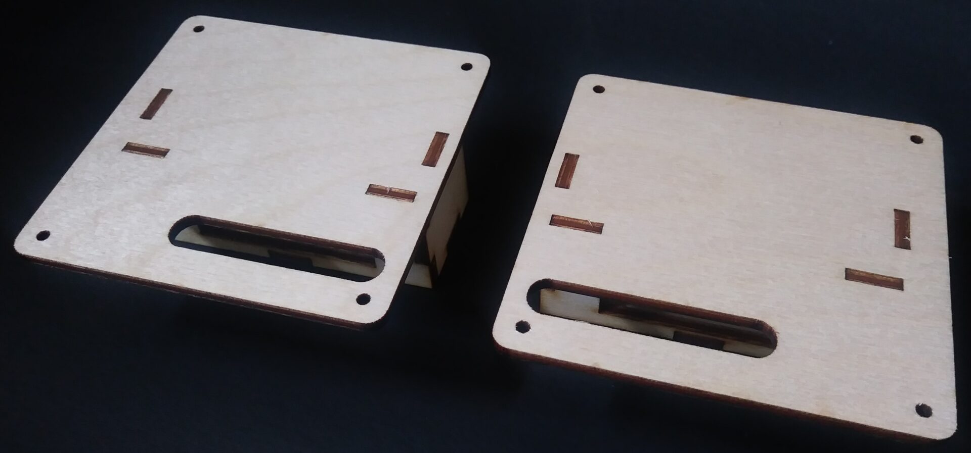 A pair of wooden boxes on a black surface.